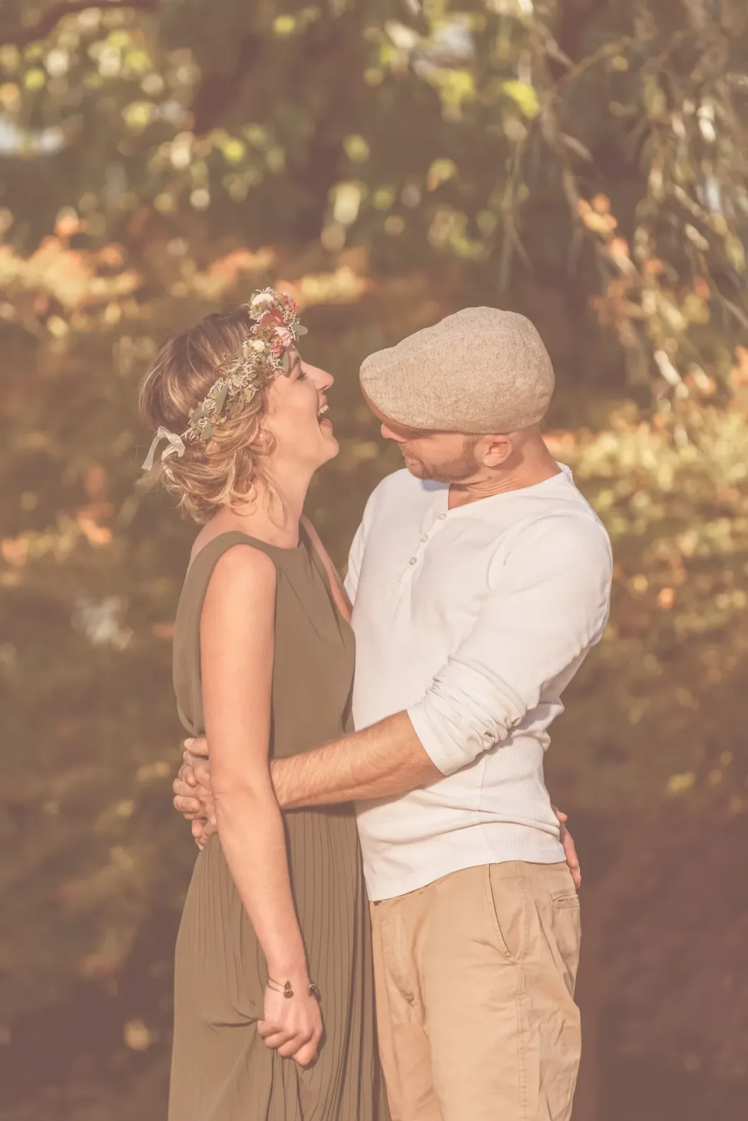 Paar im Vintage-Look lacht glücklich im Herbstgarten.