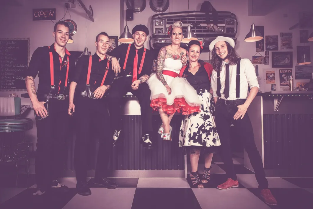 Gruppe im Retro-Stil mit vintage Kleidung und Diner-Hintergrund.
